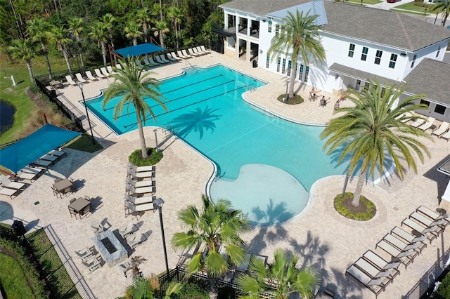 community pool with a patio and fence