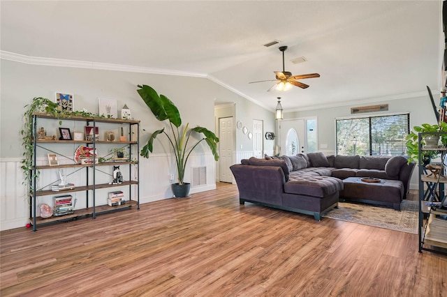 living room featuring hardwood / wood-style floors, ceiling fan, lofted ceiling, and crown molding