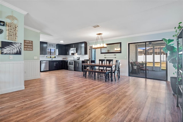 dining room featuring a chandelier, hardwood / wood-style floors, and ornamental molding