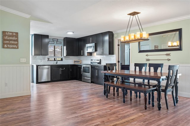 dining room featuring hardwood / wood-style floors, crown molding, sink, and a chandelier