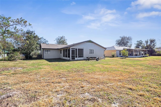 rear view of property with a sunroom and a lawn