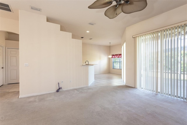 carpeted spare room with ceiling fan