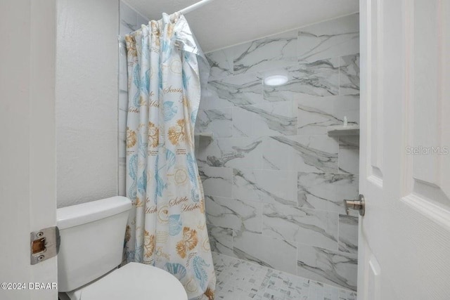 bathroom featuring a shower with curtain and toilet