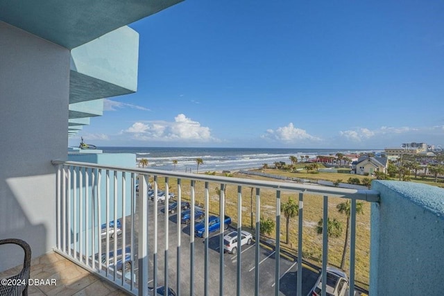 balcony featuring a view of the beach and a water view