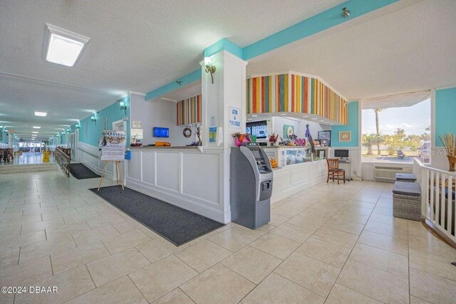 kitchen with white cabinets, light tile patterned floors, and a textured ceiling