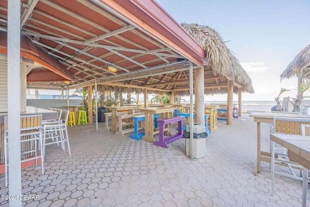 view of patio / terrace featuring a bar, a water view, and a gazebo