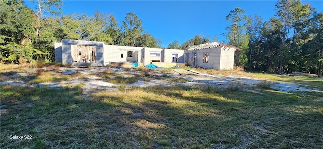 view of front of home with an outbuilding and a front lawn