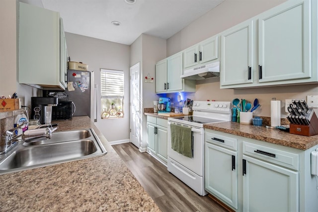 kitchen with hardwood / wood-style flooring, stainless steel fridge, white electric range, and sink