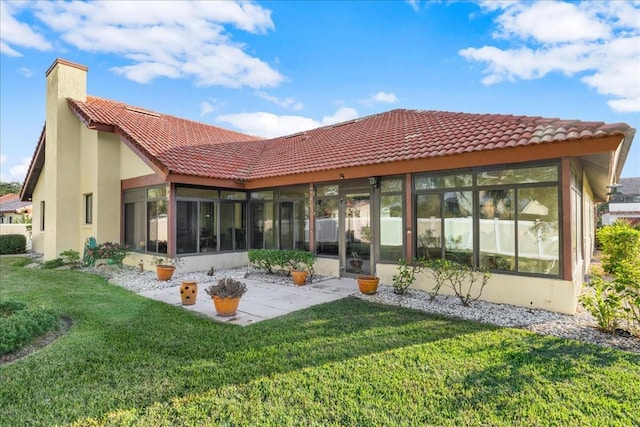 back of house featuring a lawn and a sunroom