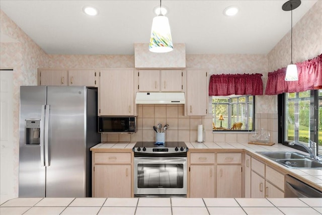 kitchen featuring light brown cabinets, sink, hanging light fixtures, appliances with stainless steel finishes, and tile counters