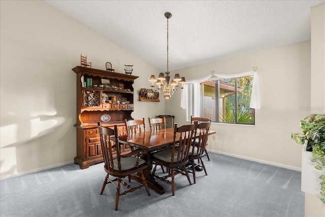 dining space with a textured ceiling, carpet floors, an inviting chandelier, and vaulted ceiling