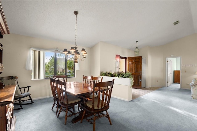 carpeted dining room with a textured ceiling, lofted ceiling, and a notable chandelier