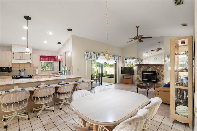 dining space featuring ceiling fan, sink, a healthy amount of sunlight, and lofted ceiling