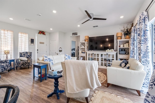 living room featuring light hardwood / wood-style floors and ceiling fan