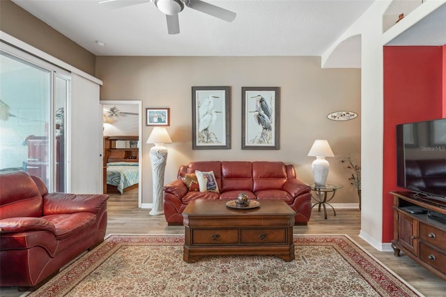 living room featuring ceiling fan, a healthy amount of sunlight, and light hardwood / wood-style flooring