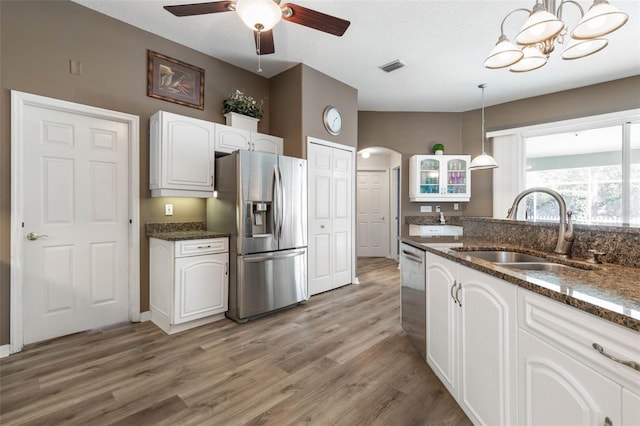 kitchen featuring sink, appliances with stainless steel finishes, decorative light fixtures, white cabinets, and hardwood / wood-style flooring