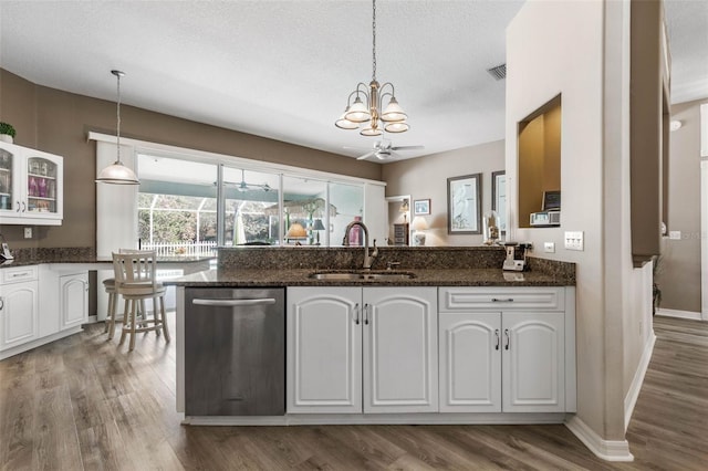 kitchen with white cabinetry, hanging light fixtures, and sink