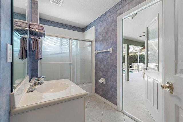 bathroom featuring tile patterned floors, vanity, shower / bath combination with glass door, and a textured ceiling