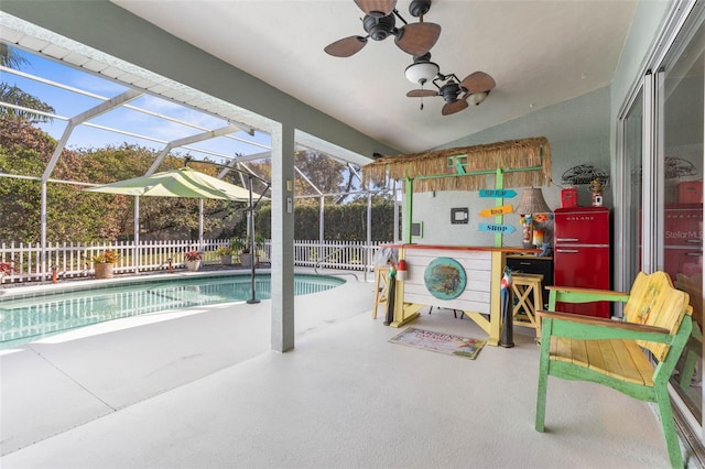 view of swimming pool featuring ceiling fan, a patio, and glass enclosure