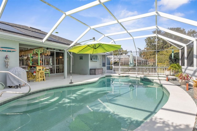 view of pool with a patio, glass enclosure, and an AC wall unit