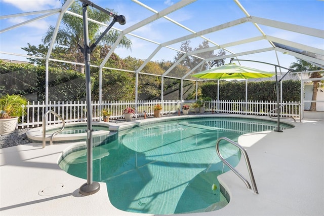 view of swimming pool with glass enclosure, an in ground hot tub, and a patio