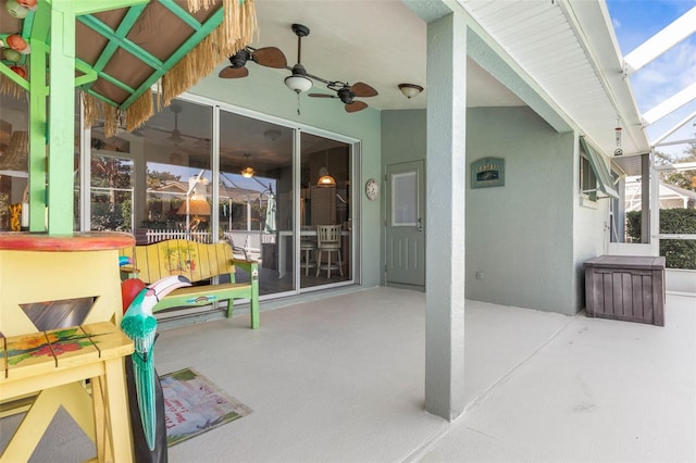 view of patio featuring glass enclosure and ceiling fan