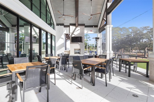 view of patio / terrace featuring ceiling fan and an outdoor fireplace