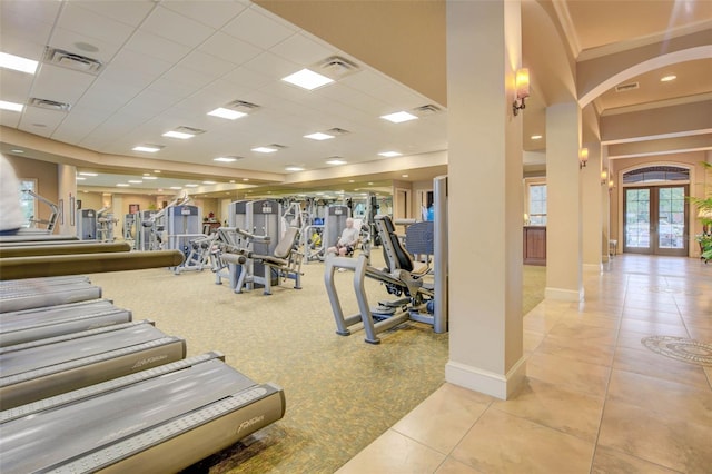 gym with french doors, light tile patterned floors, a drop ceiling, and ornamental molding