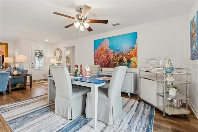 dining space with wood-type flooring and ceiling fan