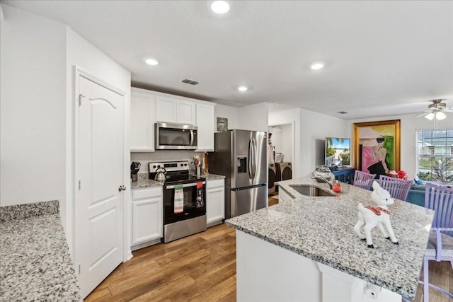 kitchen with white cabinets, sink, light wood-type flooring, and stainless steel appliances