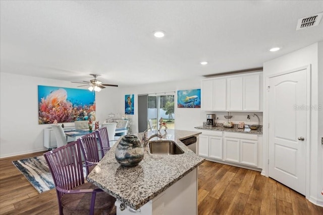 kitchen featuring hardwood / wood-style floors, an island with sink, white cabinetry, and sink