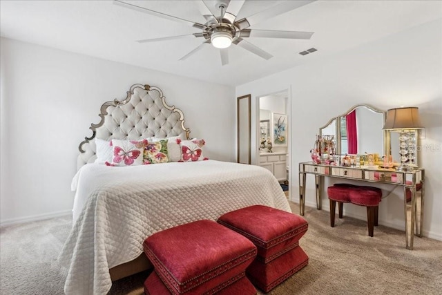 carpeted bedroom with ensuite bathroom and ceiling fan