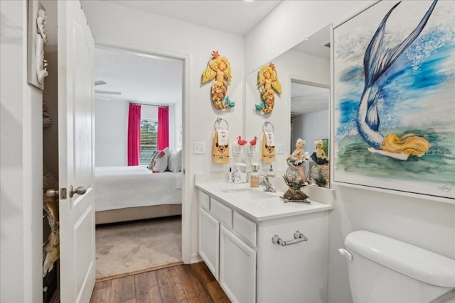 bathroom with hardwood / wood-style floors, vanity, and toilet