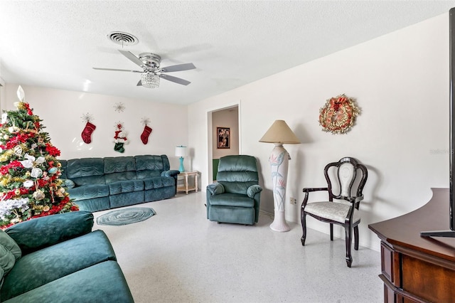 living room with ceiling fan and a textured ceiling