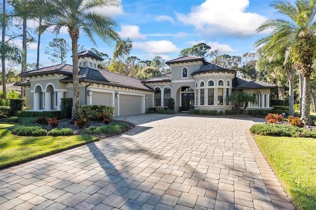 mediterranean / spanish-style home featuring a garage and a front lawn