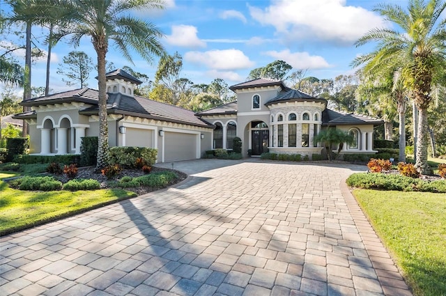 mediterranean / spanish-style home featuring a garage and a front lawn