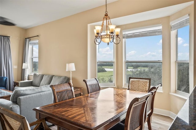 dining space featuring an inviting chandelier and light hardwood / wood-style flooring