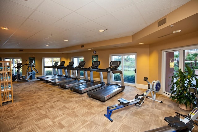 exercise room featuring a drop ceiling and carpet