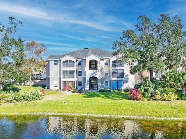 rear view of house featuring a yard and a water view