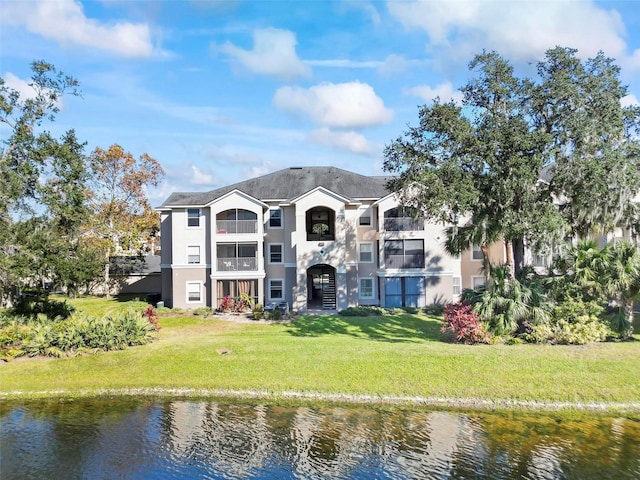 rear view of house featuring a yard and a water view