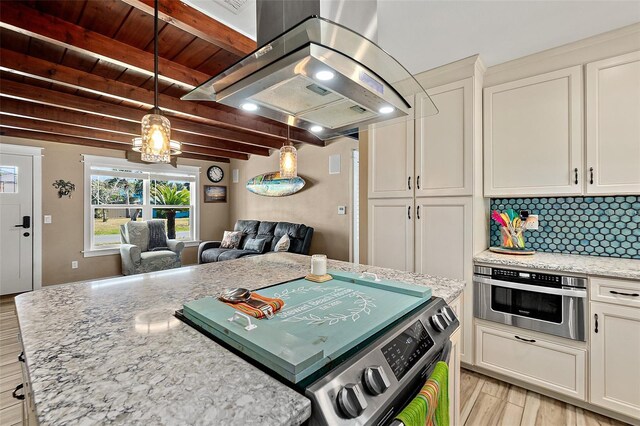 kitchen with light stone counters, beamed ceiling, backsplash, island exhaust hood, and light wood-type flooring