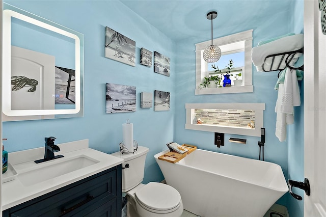 bathroom featuring a tub to relax in, vanity, and toilet