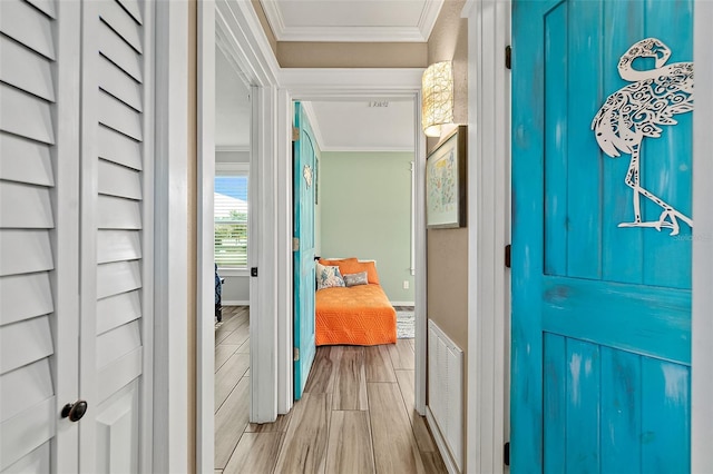 hall featuring crown molding and light hardwood / wood-style flooring