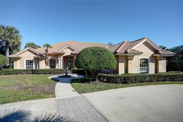 mediterranean / spanish house with a front lawn