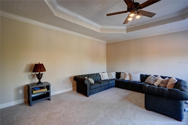 living room featuring a textured ceiling, a tray ceiling, carpet flooring, and ornamental molding