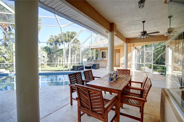 view of patio / terrace with an outdoor kitchen, ceiling fan, and a lanai