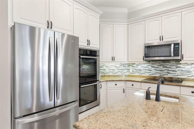 67 Island Estates Pkwy, Palm Coast, FL 32137 - kitchen featuring stainless steel appliances, a sink, white cabinets, ornamental molding, and decorative backsplash