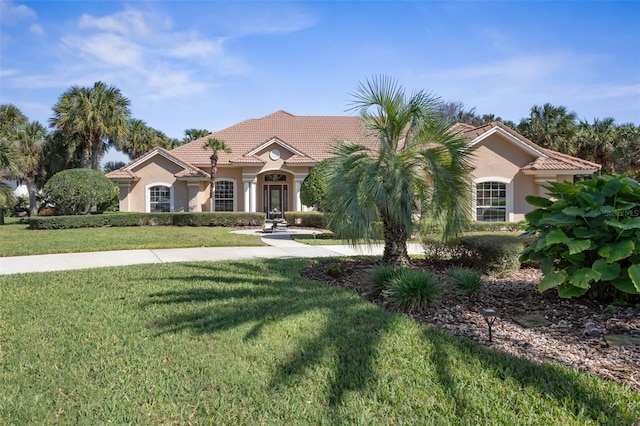 67 Island Estates Pkwy, Palm Coast, FL 32137 - mediterranean / spanish home featuring stucco siding, a front lawn, and a tile roof