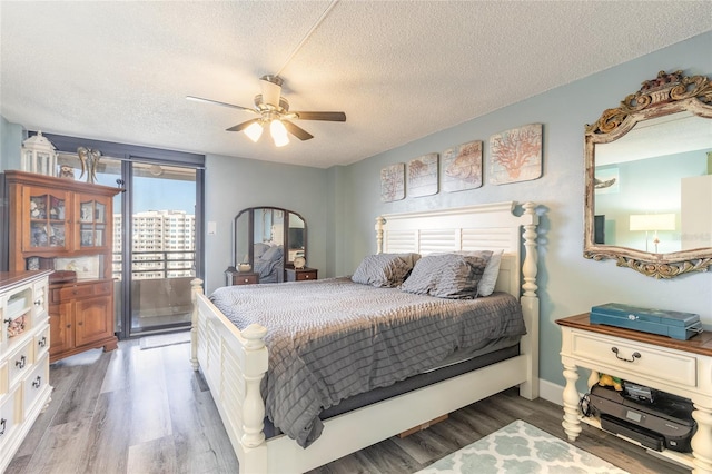 bedroom featuring hardwood / wood-style flooring, ceiling fan, and a textured ceiling