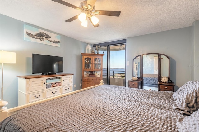 bedroom featuring access to exterior, a textured ceiling, and ceiling fan